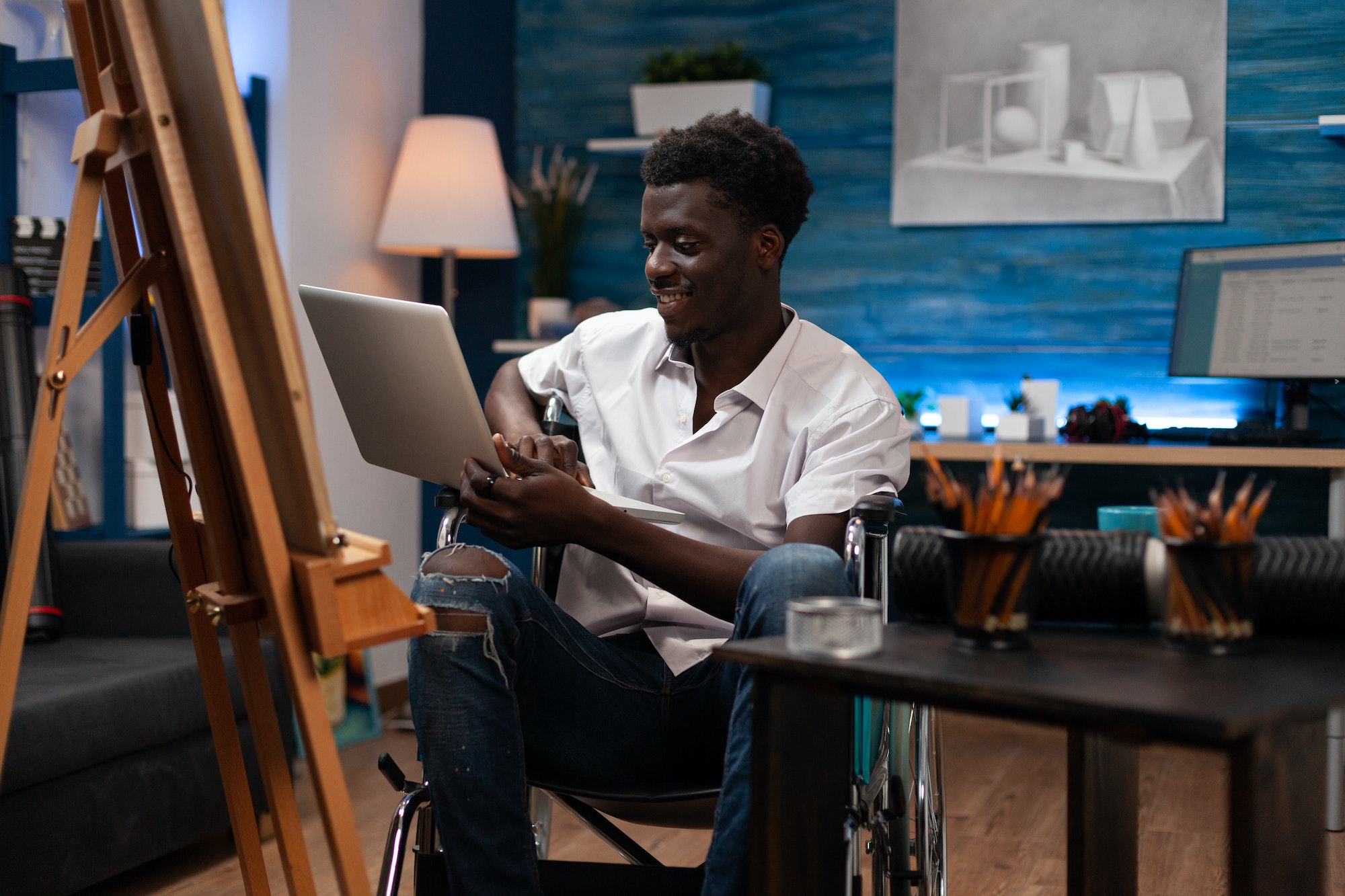 Artist with disability holding laptop computer